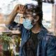 Man with Mask looking out Window